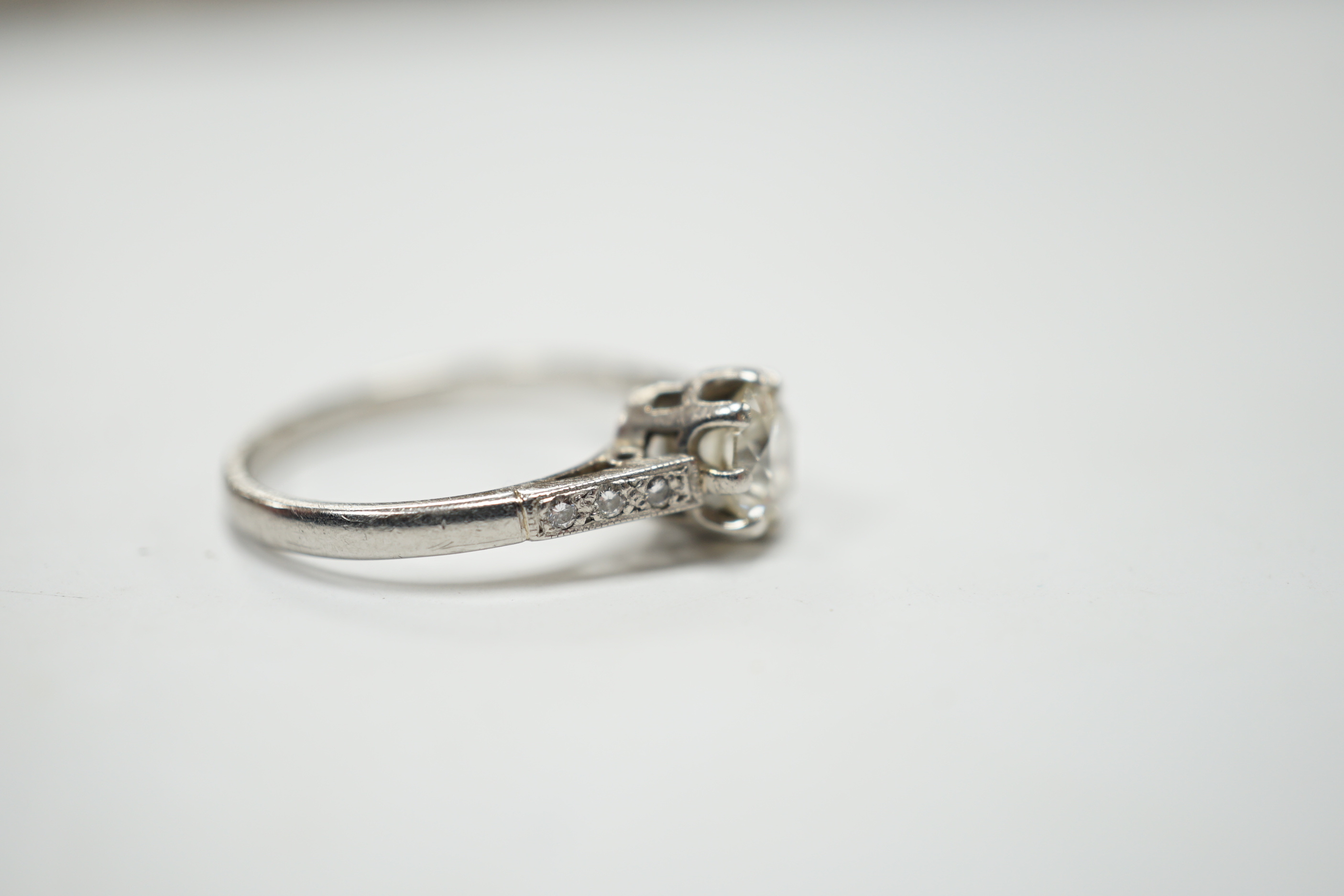A platinum and single stone diamond set ring, with six stone diamond chip set shoulders, size P, gross weight 4.5 grams